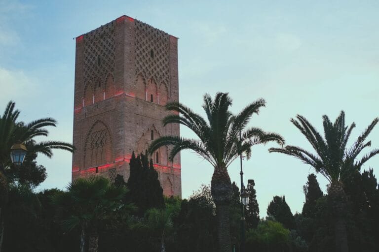 The iconic Hassan Tower surrounded by palm trees at dusk in Rabat, Morocco.rabat with kids.Is Rabat Worth Visiting With Kids