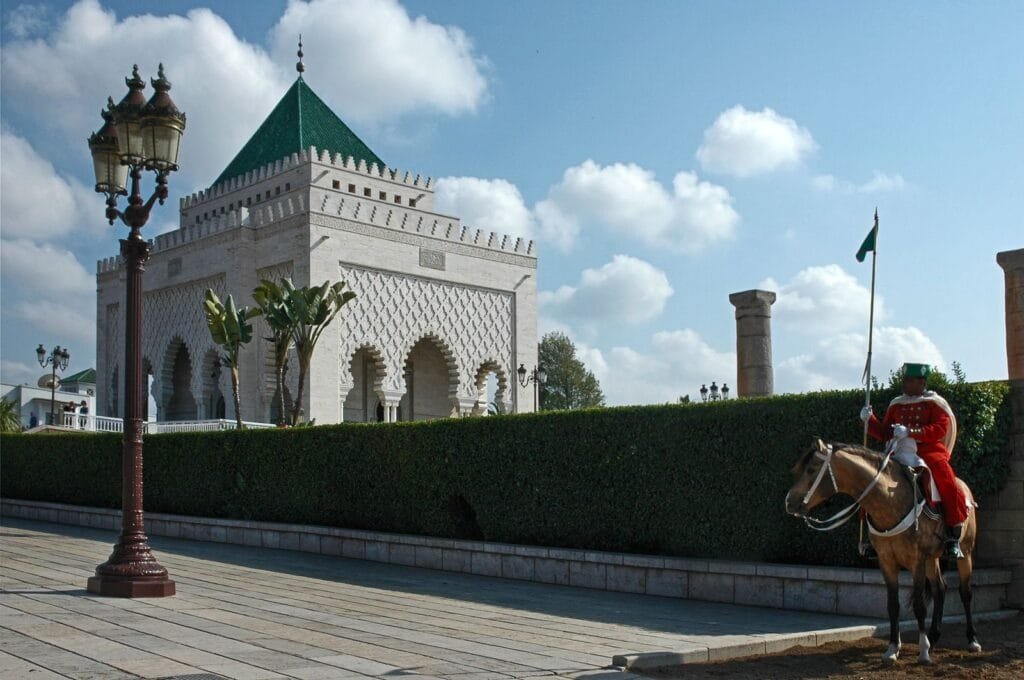 Royal guard on horseback at the Mausoleum of Mohammed V in Rabat under a bright blue sky.Is Rabat Worth Visiting With Kids