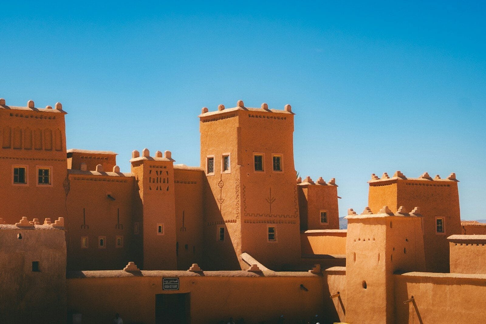 Ancient earthen fortress under a clear blue sky.mountains from Ouarzazate to Zagora Morocco