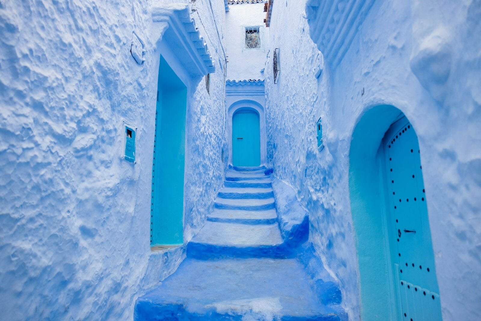 a narrow alley way with blue painted steps.Day Trip from Rabat to Chefchaouen