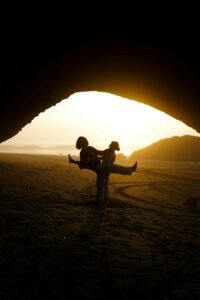 A couple of people standing in a cave.Legzira Beach: