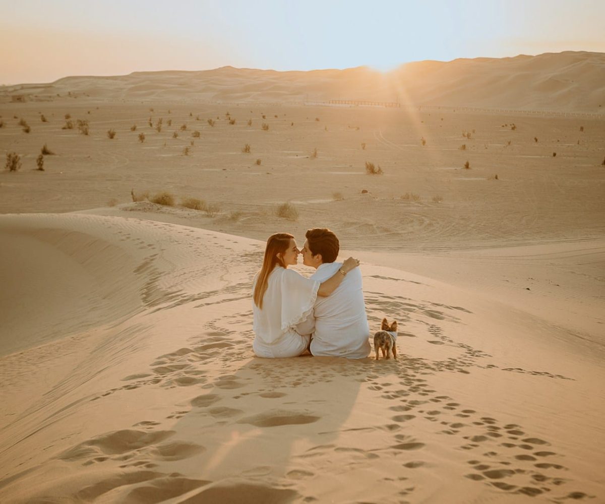 couple sitting on sand during daytime,marrakech to merzouga