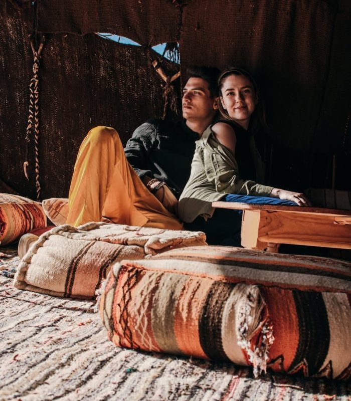 Young couple enjoying leisure time in a cozy Merzouga tent. Cultural and romantic atmosphere.
