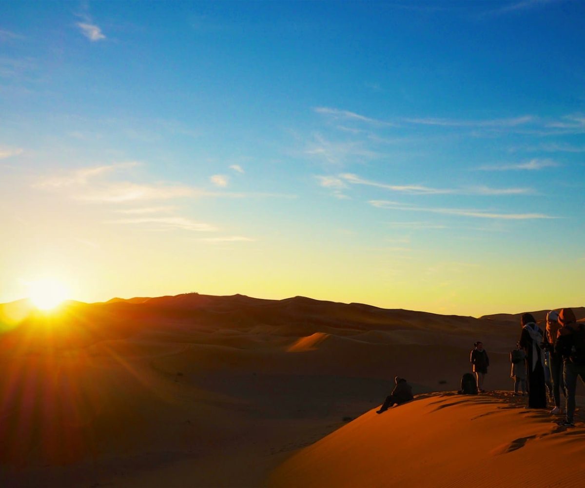 a group of people standing on top of a sand dune,4 days tour from marrakech to fes