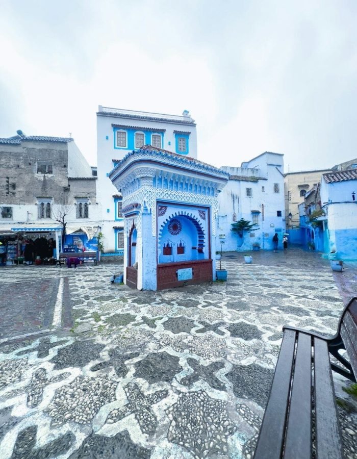 a bench sitting in front of a blue building
