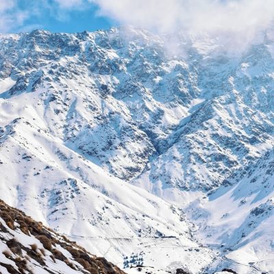 snow covered mountain under cloudy sky during daytime,kate carter
