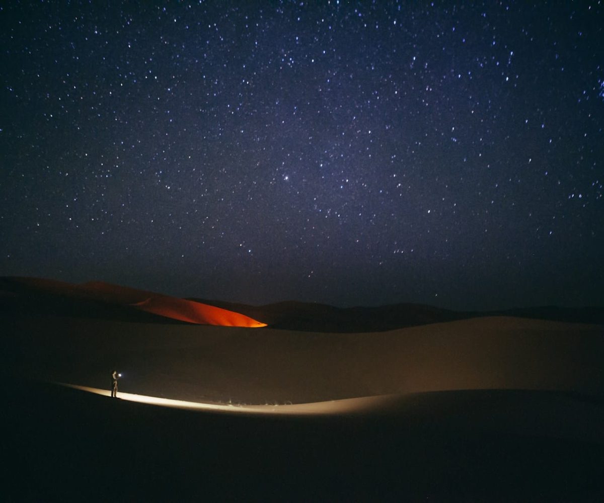 a person standing in the middle of a desert at night,5 days marrakech to merzouga tour