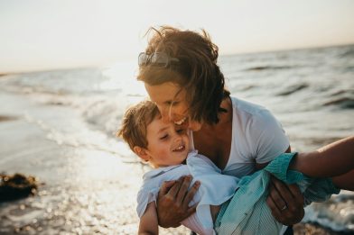 photo of mother and child beside body of water.family in sahara