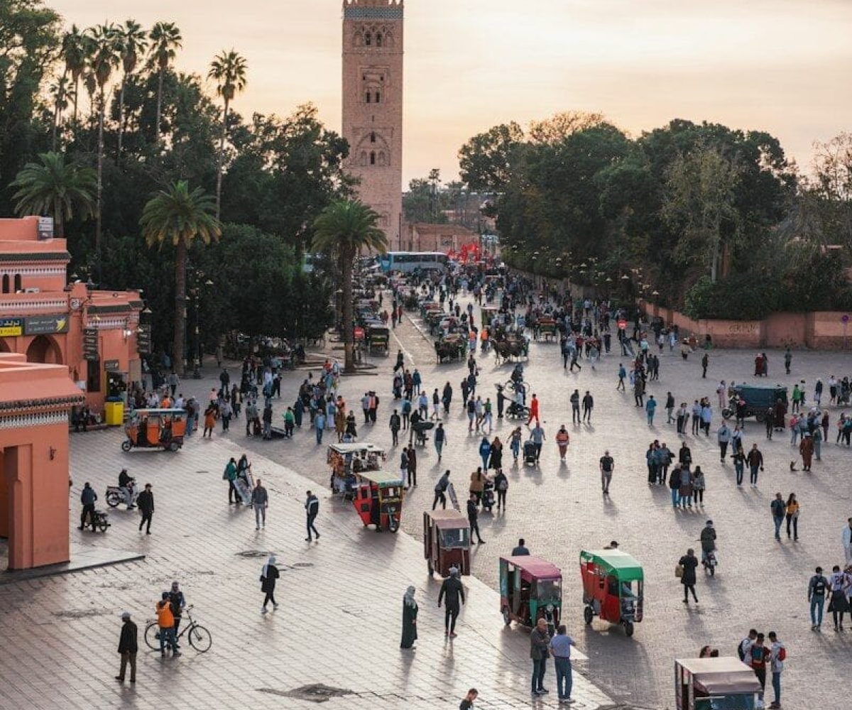 a large group of people walking around a plaza