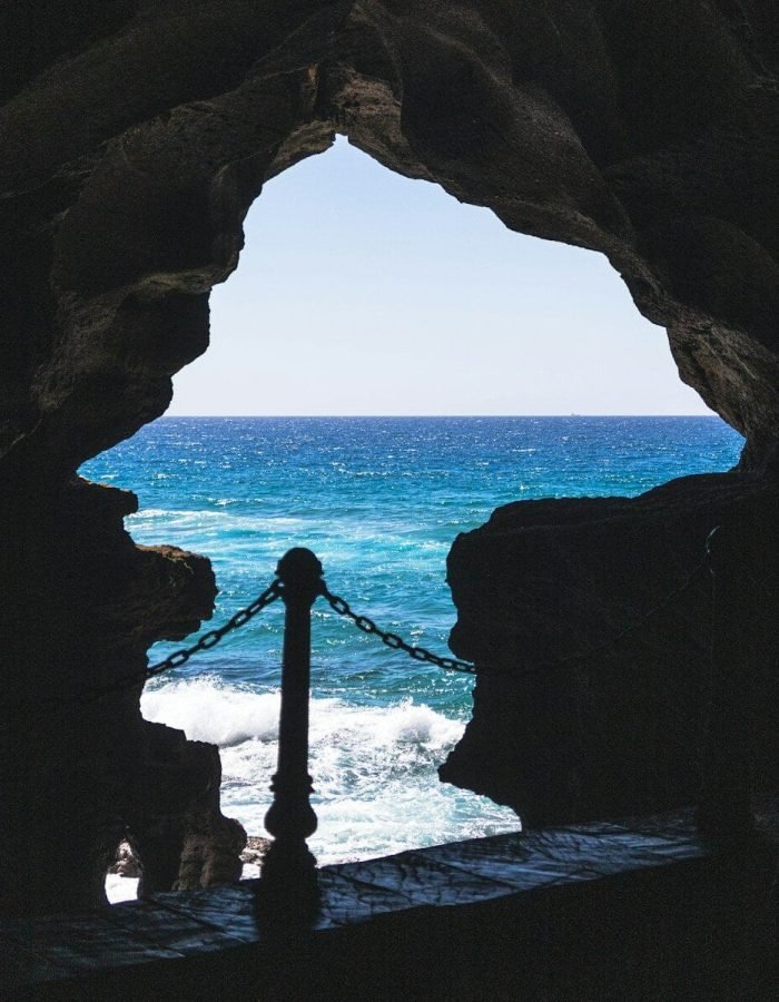 a view of a body of water from inside a cave