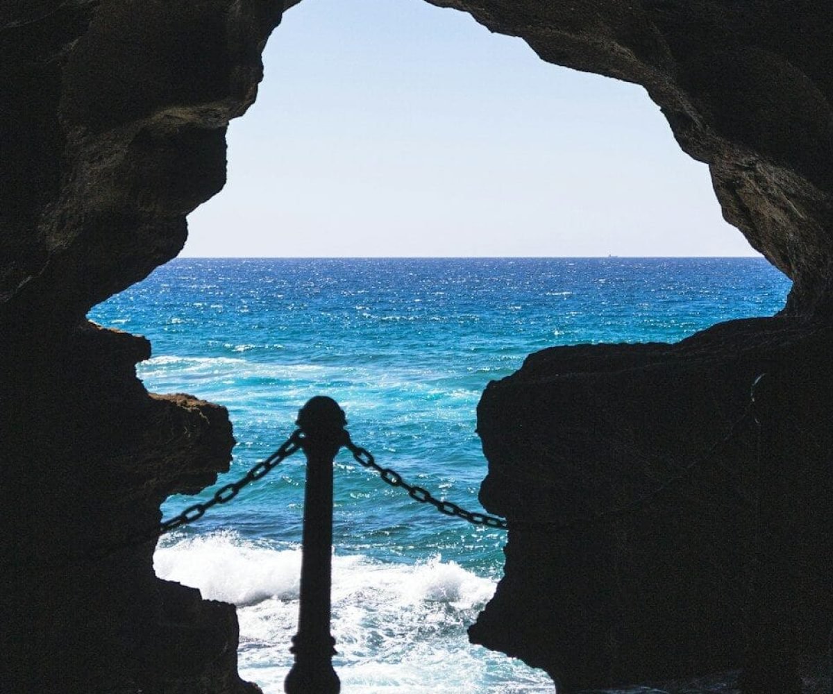 a view of a body of water from inside a cave