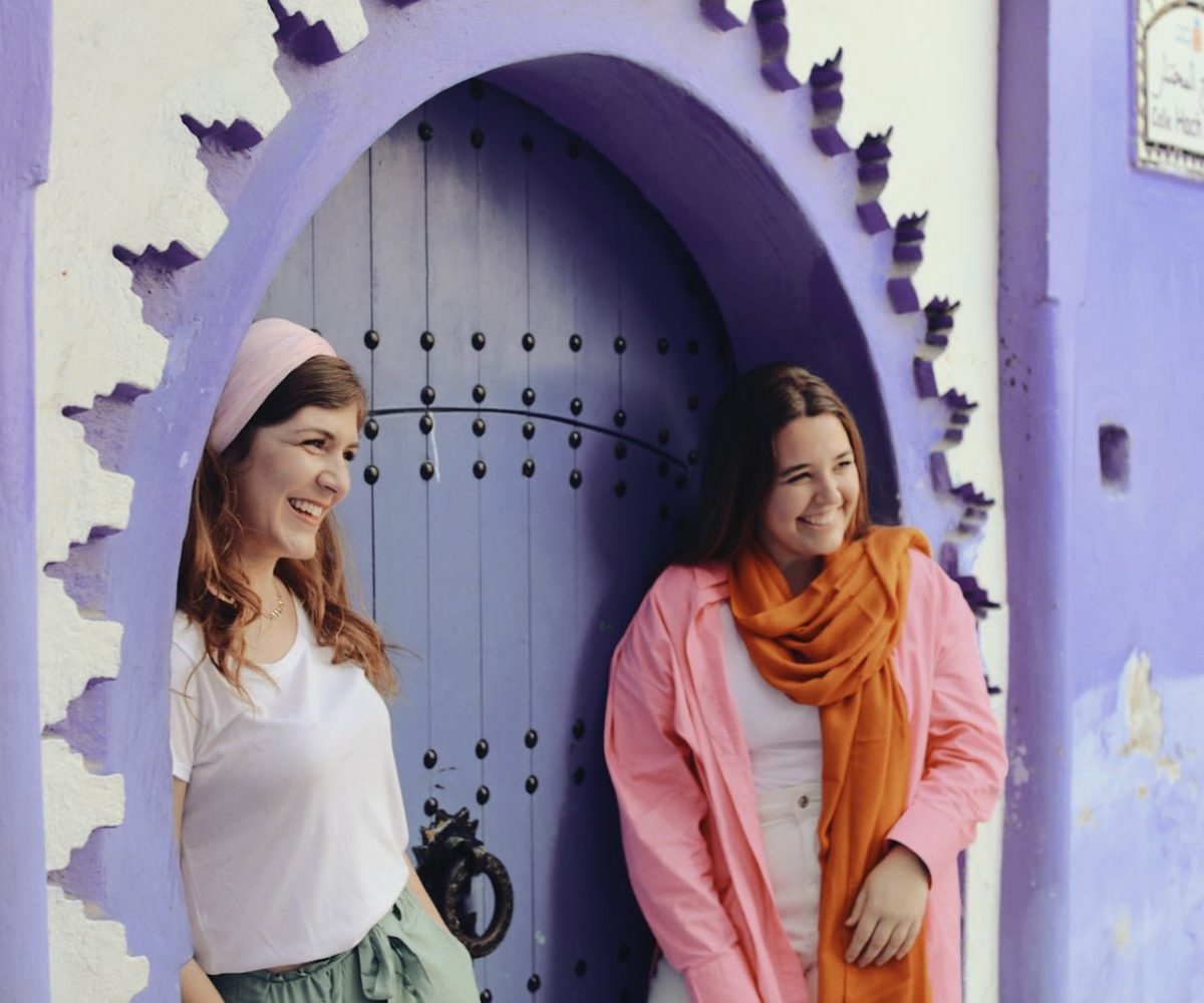 two women standing in front of a purple door,10 day Morocco tour from Casablanca