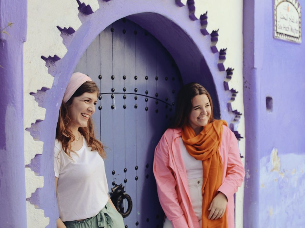 two women standing in front of a purple door.12 day morocco family vacation