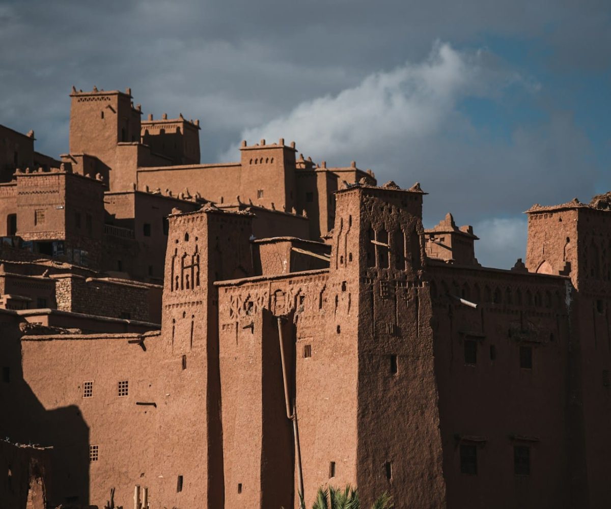a large brown building sitting on top of a lush green field,4 days tour from marrakech to fes